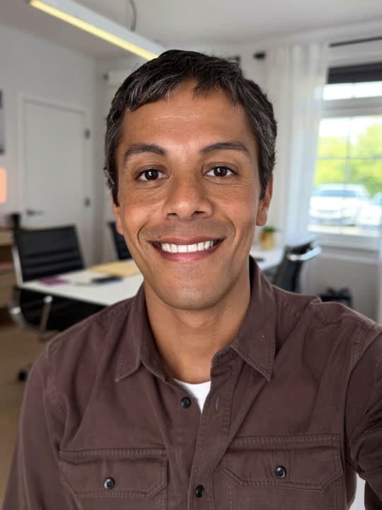 Portrait d’un fondateur souriant, face caméra, dans un bureau lumineux.